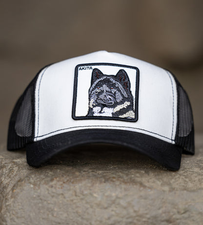 Akita dog patch trucker hat – black and white embroidered DogKingdom cap on stone surface