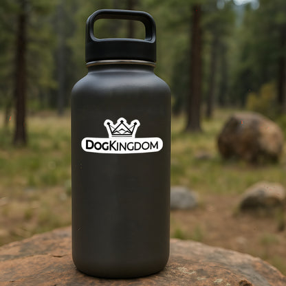 Black water bottle outdoors featuring a DogKingdom crown logo sticker in a forest setting