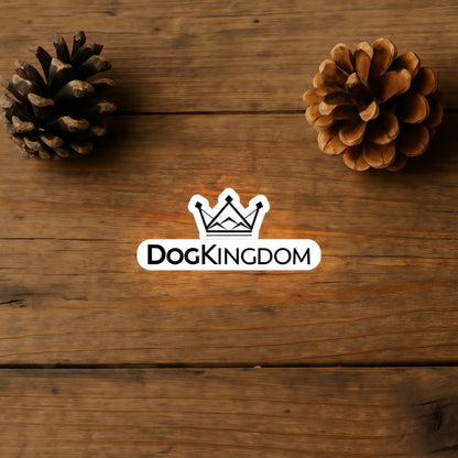 DogKingdom crown logo sticker on a wooden surface with pinecones